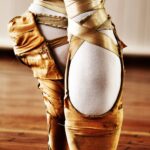 A close up of the feet and ankles of a ballet dancer.