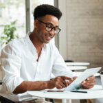 A man sitting at a table with a tablet.