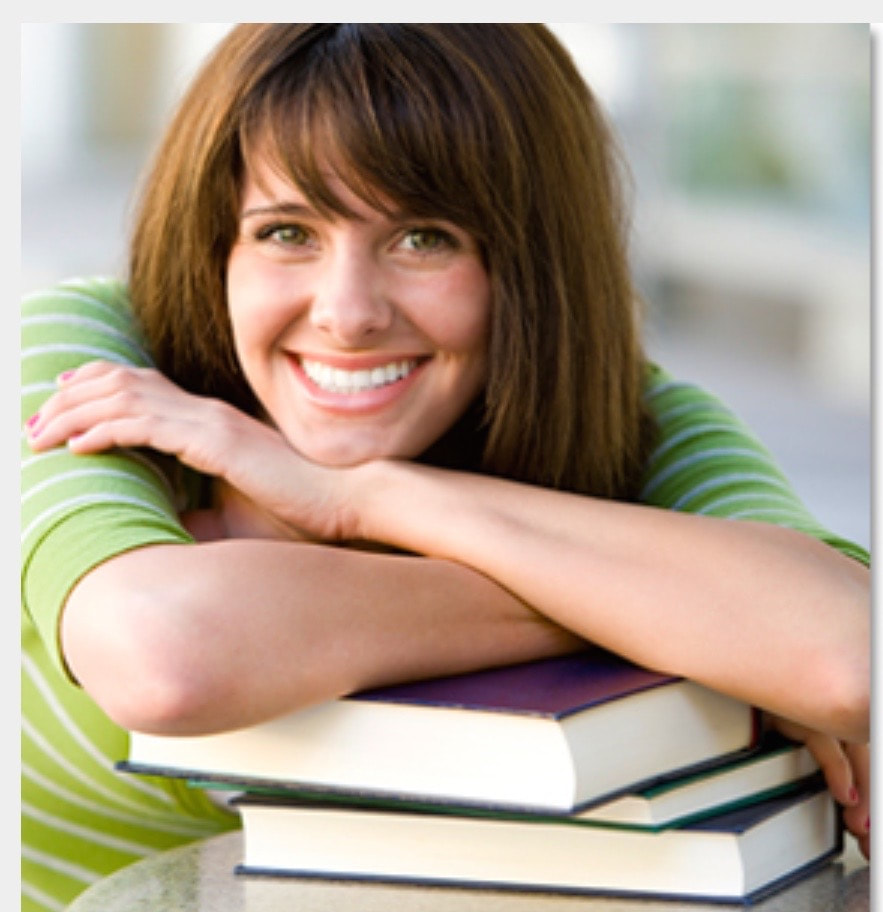 Smiling student resting on books.